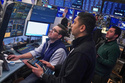 Traders Joseph Lawler, left, and Niall Pawa, center, and Drew Cohen work on the floor of the New York Stock Exchange, Thursday, Feb. 19, 2026. (AP Photo/Richard Drew)