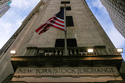 FILE - An American flag is displayed over an entrance to the New York Stock Exchange in New York, Feb. 12, 2026. (AP Photo/Seth Wenig, File)