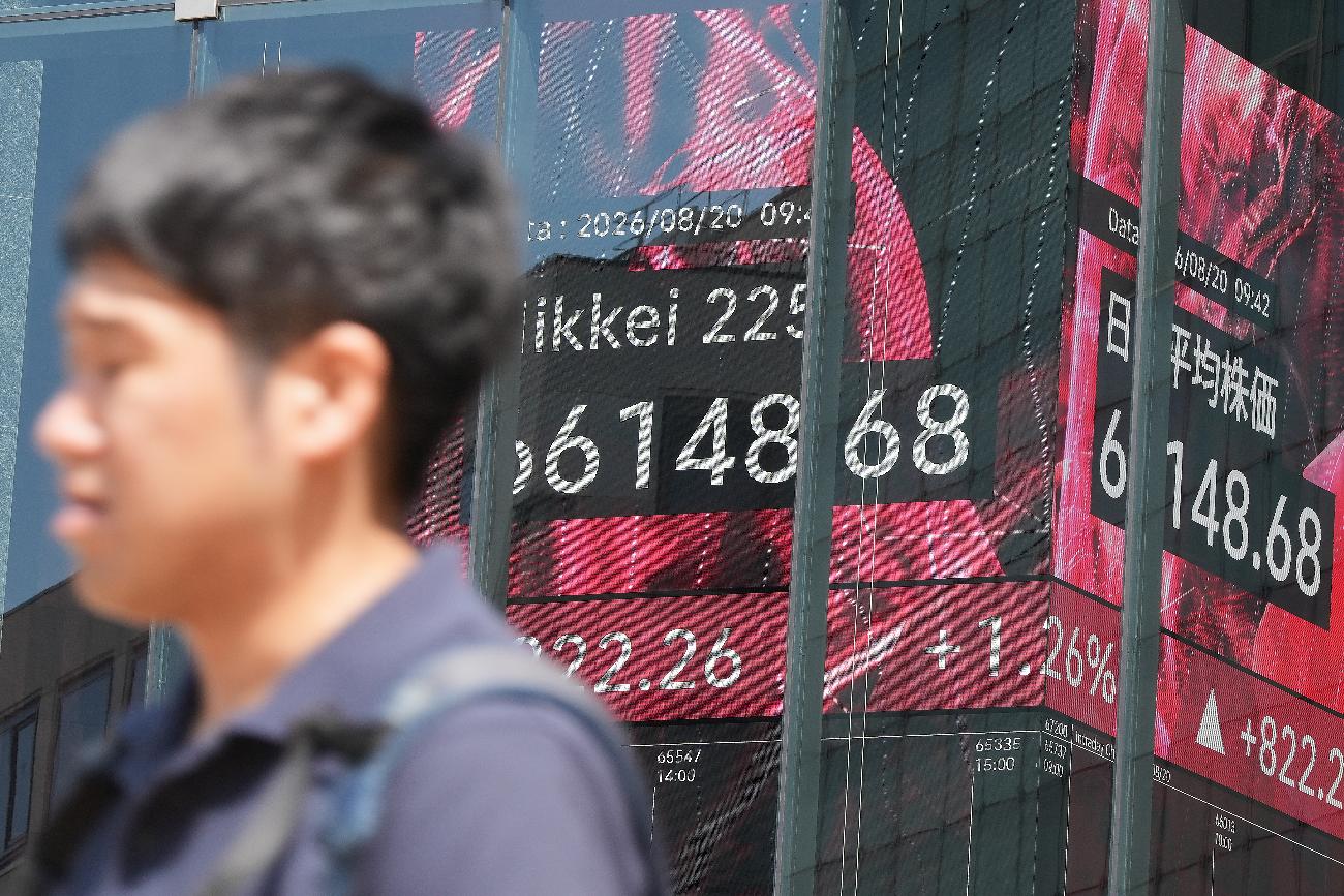 A person walks in front of an electronic stock board showing Japan's Nikkei index at a securities firm Thursday, Aug. 20, 2026, in Tokyo. (AP Photo/Eugene Hoshiko)