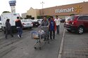 FILE - In this Dec. 26, 2013 file photo, a family leaves a local Walmart in Mexico City. Walmart de Mexico, the country’s biggest retailer, announced the week of June 18, 2021, that its grocery store baggers wouldn’t be allowed back, as the coronavirus pandemic and changing consumer habits threaten to put an end to a decades-old practice of allowing elderly people in Mexico to earn extra income as baggers. (AP Photo/Marco Ugarte, File)