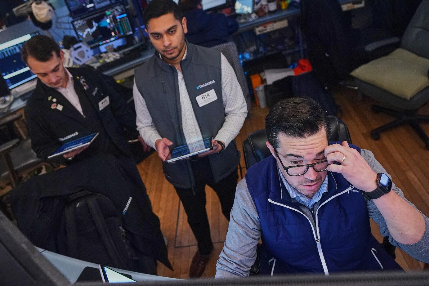 Joseph Lawler, right, works with fellow traders on the floor of the New York Stock Exchange, Thursday, April 23, 2026. (AP Photo/Richard Drew)