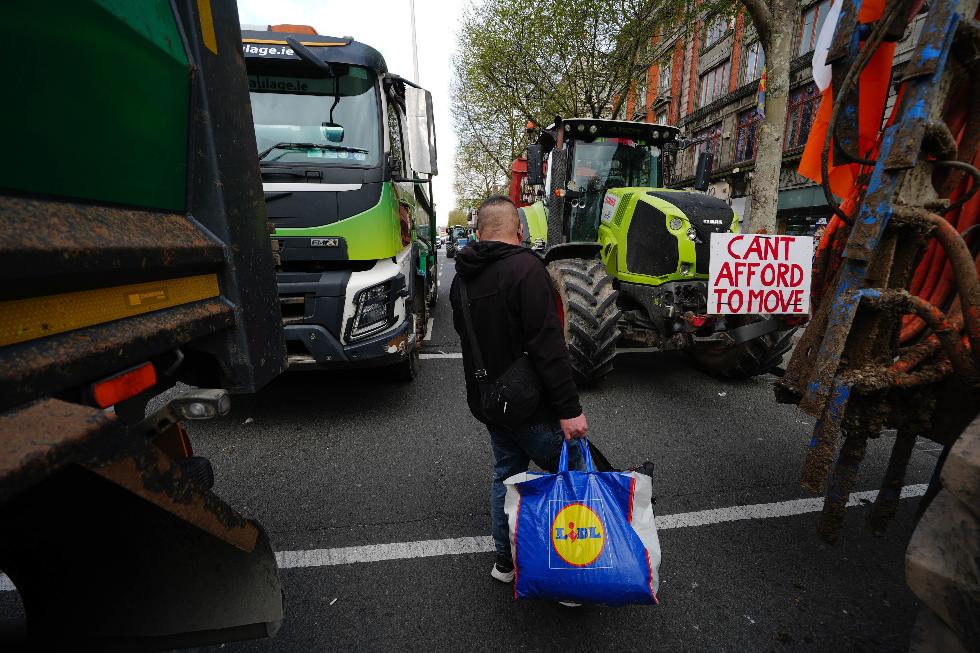 A man walks in between vehicles parked on O'Connell Street on the second day of a national fuel protest against rising fuel prices, in Dublin, Ireland, Wednesday April 8, 2026. (Brian Lawless/PA via AP)