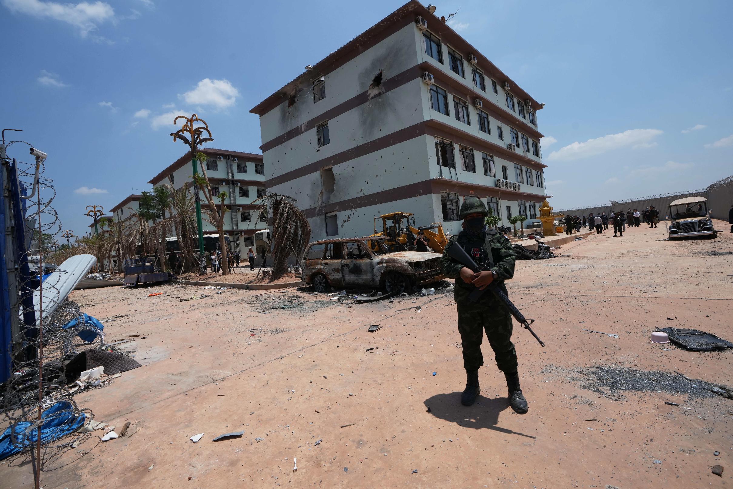 A Thai soldier guards outside the scam compound in O'Smach, Cambodia, Tuesday, April 7, 2026. (AP Photo/Sakchai Lalit)