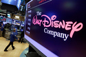 FILE - In this Aug. 8, 2017, file photo, The Walt Disney Co. logo appears on a screen above the floor of the New York Stock Exchange. (AP Photo/Richard Drew, File)