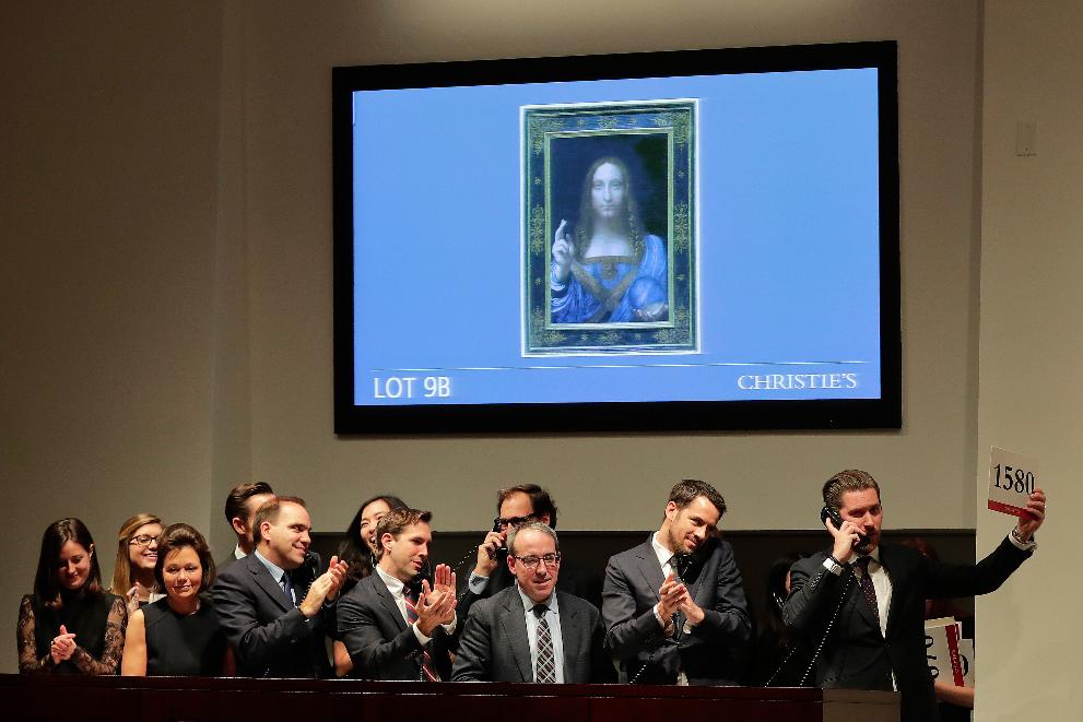 FILE - Bidding representatives react after Leonardo da Vinci's "Salvator Mundi" sold for $450 million at Christie's in New York, Nov. 15, 2017. (AP Photo/Julie Jacobson, File)