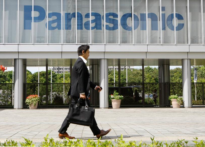 FILE - A businessman walks past a corporate logo of Japanese electronics maker Panasonic Corp. at Panasonic Center in Tokyo, Japan, Sept. 10, 2009. (AP Photo/Shizuo Kambayashi, File)