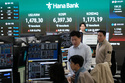 Currency traders work near a screen showing the Korea Composite Stock Price Index (KOSPI), top center, and the foreign exchange rate between U.S. dollar and South Korean won, top center left, at the foreign exchange dealing room of the Hana Bank headquarters in Seoul, South Korea, Wednesday, April 22, 2026. (AP Photo/Ahn Young-joon)