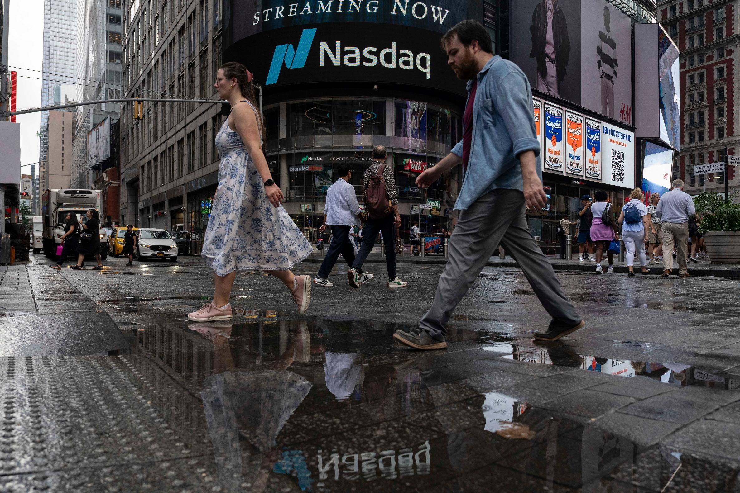 People walk past the Nasdaq MarketSite, Thursday, Aug. 6, 2026, in New York. (AP Photo/Yuki Iwamura)