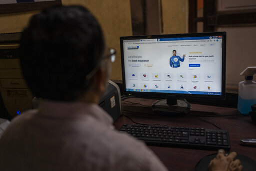 A man looks at the website of policybazaar website at a local insurance company office in Mumbai, India, Wednesday, Aug. 10, 2022. A cybersecurity firm told the major Indian online insurance brokerage last month that critical vulnerabilities in the company’s internet-facing network could expose sensitive personal and financial data from its 11 million customers. CyberX9 followed the standard ethical-hacker playbook, giving the brokerage time to patch the flaws and inform authorities. A week later, publicly traded Policybazaar said it had been illegally breached but “no significant customer data was exposed.” (AP Photo/Rafiq Maqbool)