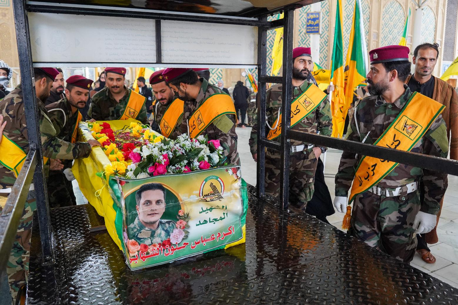 Members from Kataib Hezbollah attend the funeral of their colleagues who were killed in a U.S. airstrike in Qaim province, according to their statement, in Najaf, Iraq, Thursday, March 19, 2026. (AP Photo/Anmar Khalil)
