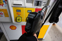 FILE - A gas price is displayed as a customer holds a fuel pump nozzle before filling up her vehicle's gas tank at a gas station, in Lincolnshire, Ill., Wednesday, April 15, 2026. (AP Photo/Nam Y. Huh, file)