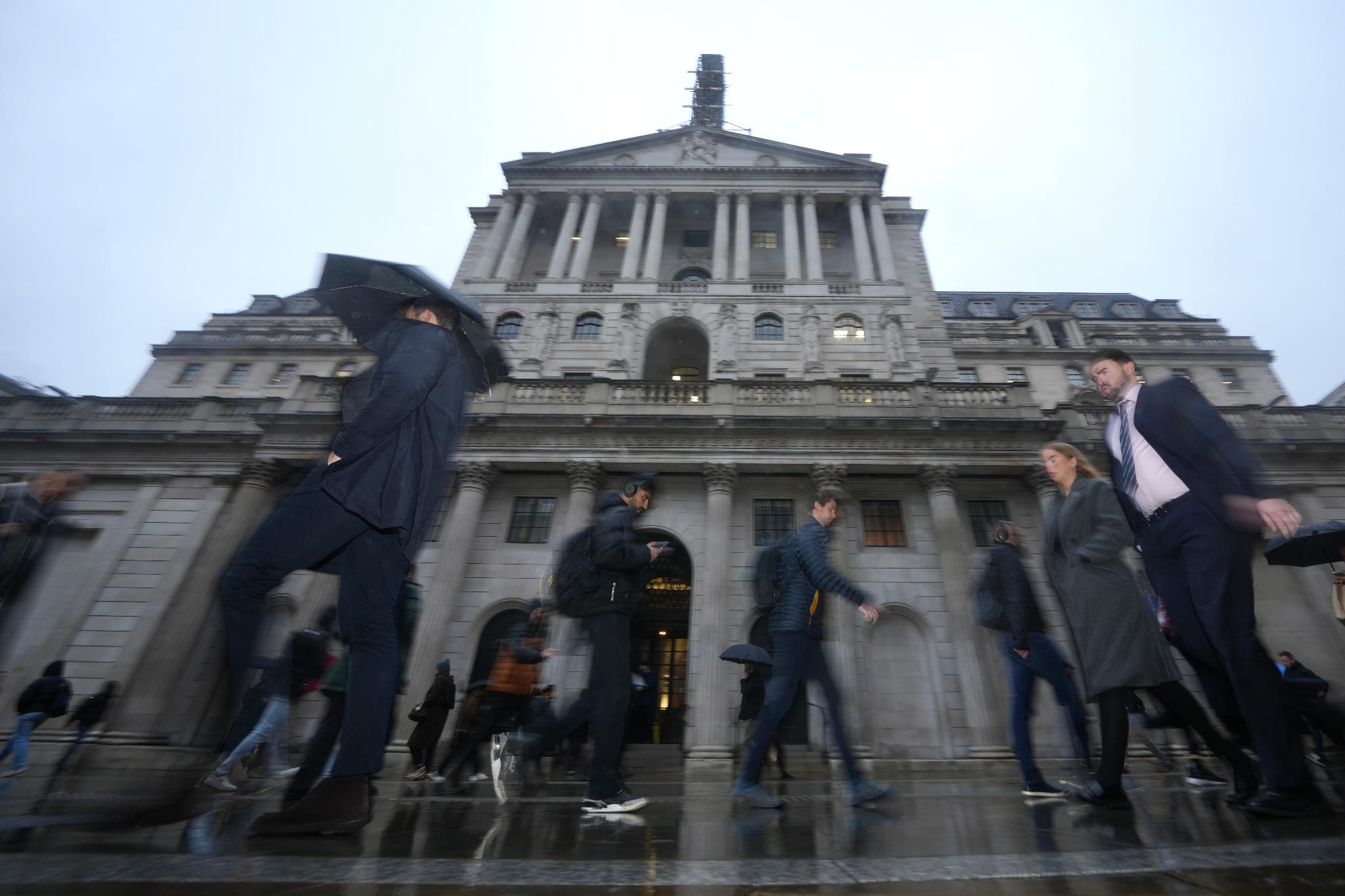 People walk in front of the Bank of England, at the financial district in London, Thursday, Feb. 5, 2026 as the Bank of England holding its first interest rate meeting in 2026 at a time when inflation in the UK remains above target and economic growth is stubbornly low. (AP Photo/Kin Cheung)