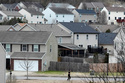 A person jogs past single family homes, Tuesday, Feb. 10, 2026, in Nashville, Tenn. (AP Photo/George Walker IV)