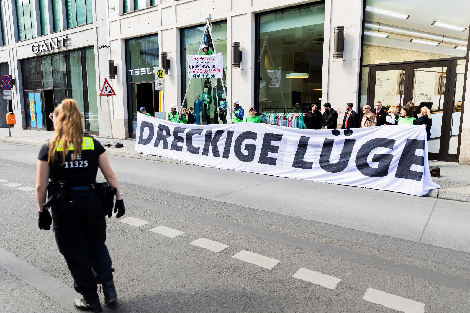 "Clean cars are a dirty lie" is written on a banner in front of the Tesla store in the Mall of Berlin, Friday May 10, 2024 during a protest. German police said Friday they had prevented hundreds of demonstrators from storming Tesla’s factory near Berlin during protests against the pioneering electric car maker over its environmental footprint. (Christoph Soeder/dpa via AP)