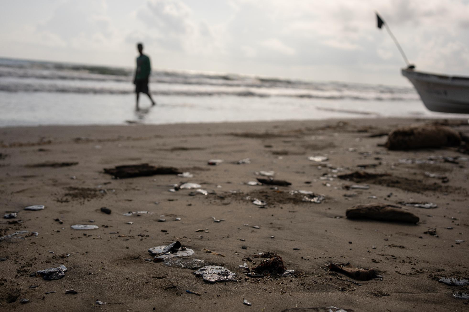 Clumps of oil residue lie on the shore after fishing outings were suspended because of an oil spill that Mexican authorities said originated from an unidentified vessel and two natural oil seeps along the Gulf coast in Salinas, Mexico, Thursday, March 26, 2026. (AP Photo/Felix Marquez)