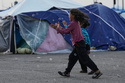 Girls chase bubbles next to their family's tents used as shelter after fleeing Israeli bombardment in Dahiyeh, Beirut's southern suburbs, in Beirut, on Wednesday, April 15, 2026. (AP Photo/Bilal Hussein)