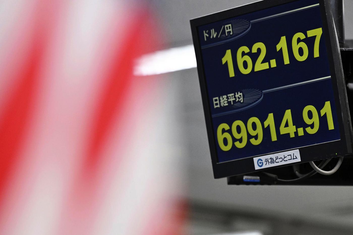 An electronic board shows Japan's benchmark Nikkei 225 index, bottom, and exchange rate of the Japanese yen against the U.S. dollar in Tokyo Tuesday, June 30, 2026. (Kenichiro Kojima/Kyodo News via AP)