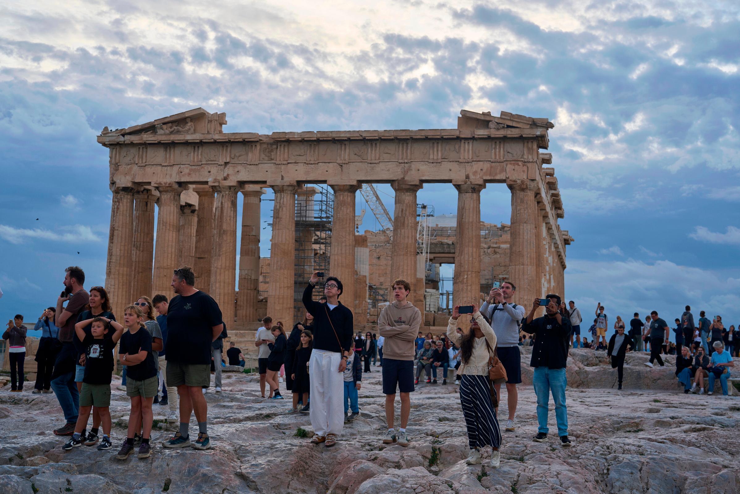 FILE - Tourists visit the Acropolis hill with he 5th century B.C. Parthenon, in Athens, Friday, Oct. 31, 2025. (AP Photo/Petros Giannakouris, File)