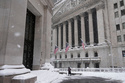A pedestrian walks outside the New York Stock Exchange during a snow storm, Monday, Feb. 23, 2026, in New York. (AP Photo/Seth Wenig)
