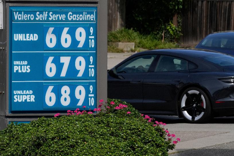 A car drives behind the gasoline price board at a Valero gas station in San Francisco, Saturday, April 4, 2026. (AP Photo/Jeff Chiu)