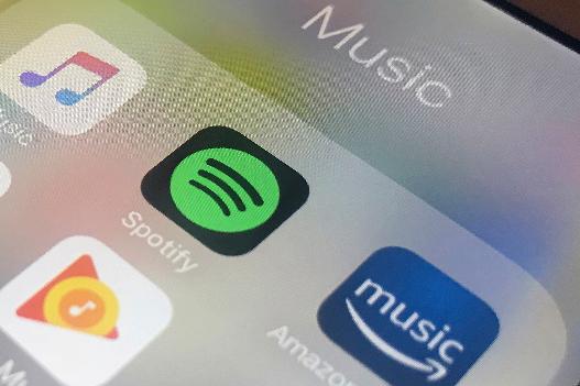 FILE - Music streaming apps, clockwise from top left, Apple, Spotify, Amazon and Google are displayed on an iPhone in New York, Jan. 28, 2018. (AP Photo/Jenny Kane, File)