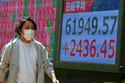 A person walks in front of an electronic stock board showing Japan's Nikkei index at a securities firm Thursday, May 7, 2026, in Tokyo. (AP Photo/Eugene Hoshiko)