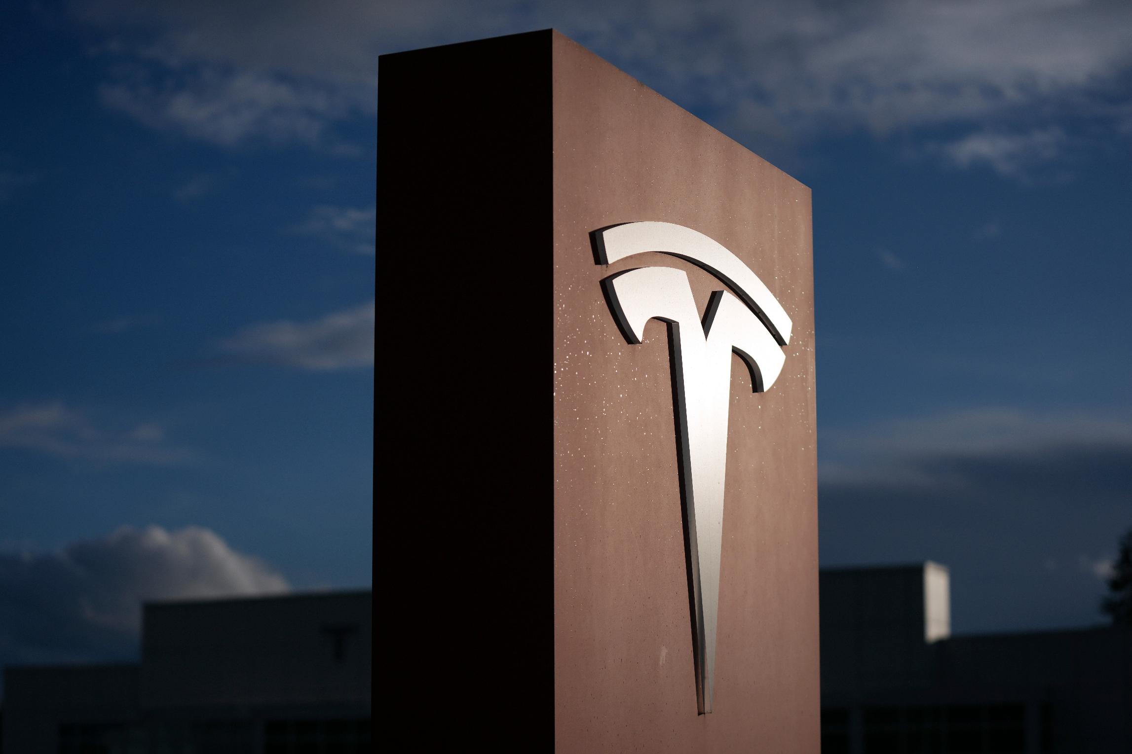 FILE - A sign for Tesla is displayed at a facility on Wednesday, April 15, 2026, in Portland, Ore. (AP Photo/Jenny Kane, File)