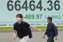People walk in front of an electronic stock board showing Japan's Nikkei index at a securities firm Tuesday, June 2, 2026, in Tokyo. (AP Photo/Eugene Hoshiko)