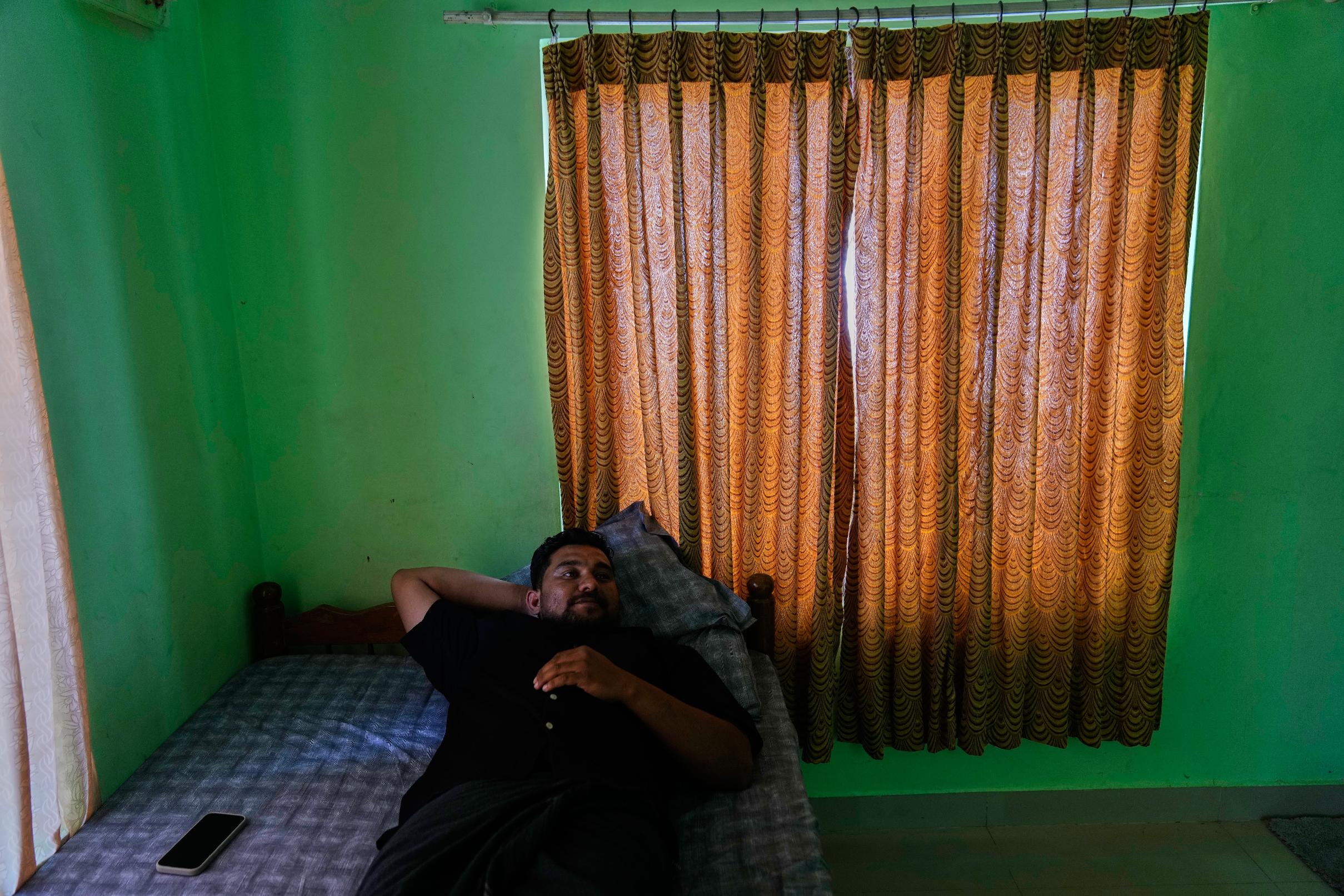 Safeer Mohammed Koorimannil rests in his brother's house after work, in Sulthan Bathery in the southern state of Kerala, India, Thursday, March 12, 2026, where he returned after paying to be freed from a scam compound in Myanmar. (AP Photo/Manish Swarup)