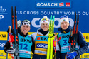 Winner Johannes Hoesflot Klaebo of Norway, centre, second placed Gus Schumacher of United States, left, and Edvin Anger of Sweden, right, celebrate on the podium after the men's sprint final classic skiing race, during the FIS Cross-Country World Cup at the Nordic Center Goms, in Geschinen, Switzerland, Saturday, Jan. 24, 2026. (Salvatore Di Nolfi/Keystone via AP)