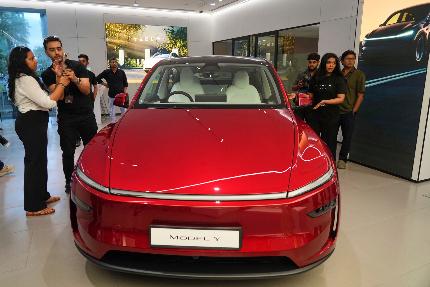 Media personnel look at the Tesla's Model Y car at the newly opened India's first Tesla showroom in Mumbai, India, Tuesday, July 15, 2025. (AP Photo/Rafiq Maqbool)