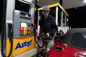 Luciano V. replaces the fuel nozzel after filling the tank of their 1999 Mazda Miata at an Astro gas station on Wednesday, April 29, 2026, in Portland, Ore. (AP Photo/Jenny Kane)