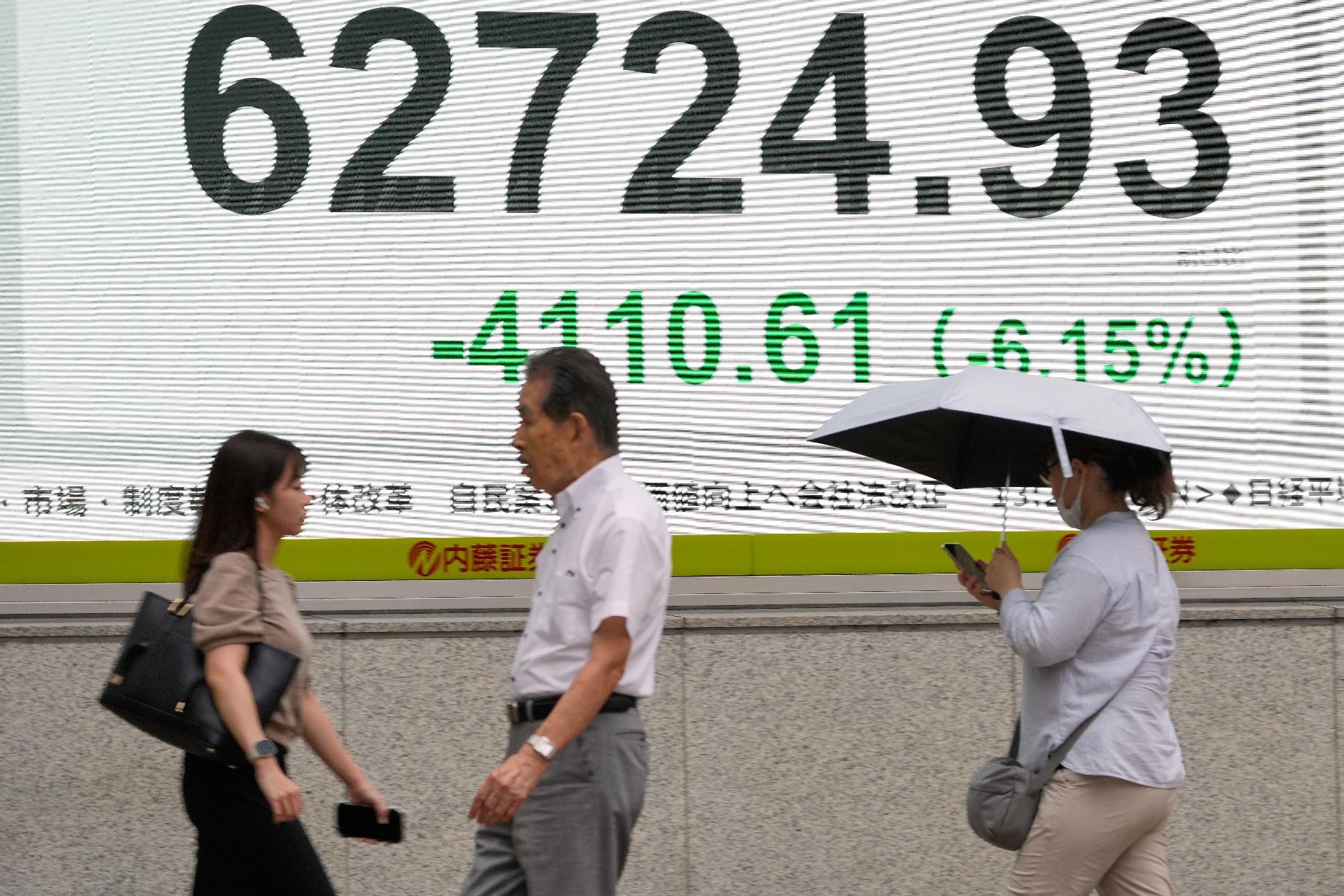 A person walks in front of an electronic stock board showing Japan's Nikkei index at a securities firm Friday, July 17, 2026, in Tokyo. (AP Photo/Eugene Hoshiko)