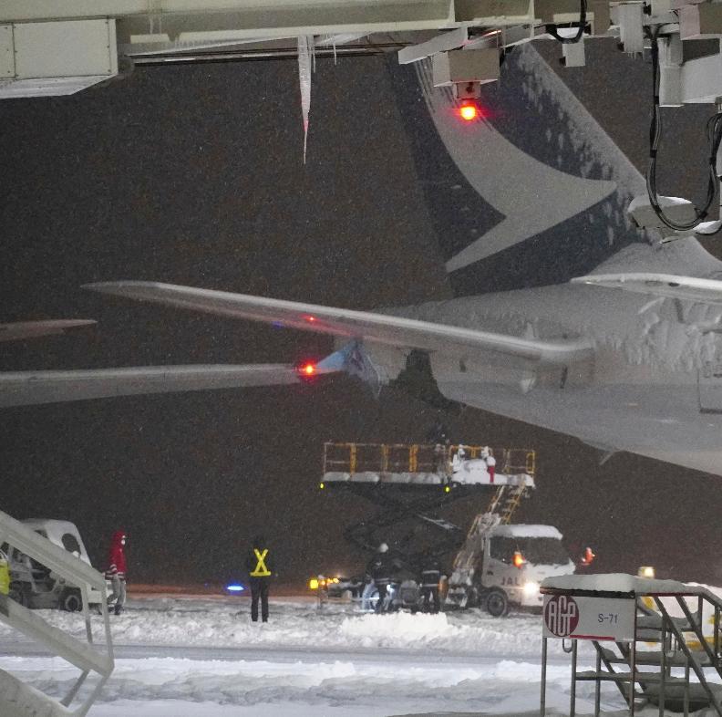 A part of wing of a Korean Air plane, left, and Cathay Pacific aircraft, right, are seen after a collision at northern Japan's New Chitose Airport in Sapporo, Tuesday, Jan. 16, 2024. A Korean Air plane carrying 289 people hit a parked Cathay Pacific aircraft while being pushed by a ground vehicle ahead of takeoff at northern Japan's New Chitose Airport on Tuesday but caused no fire or injuries, fire and airline officials said. (Kyodo News via AP)