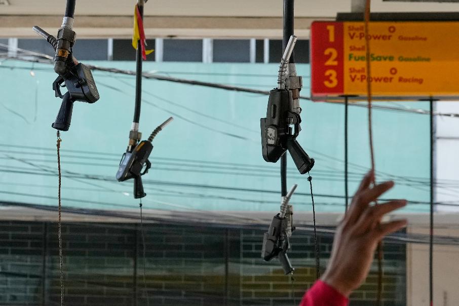 Hanging fuel nozzles are seen at a gasoline station in Manila, Philippines on Tuesday, March 3, 2026. (AP Photo/Aaron Favila)