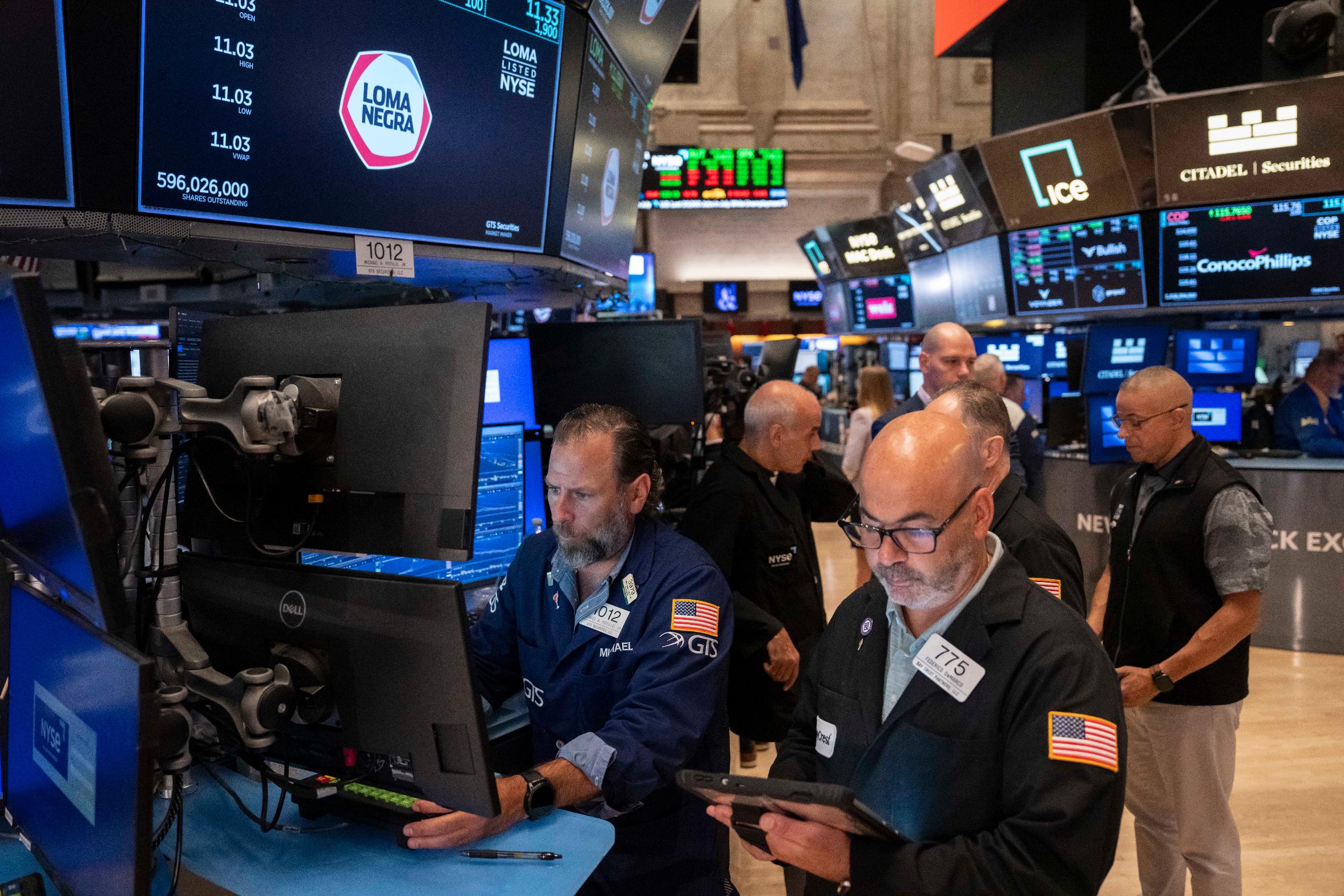 Trader Fred Demarco, right, and Specialist Michael Pistillo, left, work on the floor of the New York Stock Exchange, Friday, Aug. 7, 2026, in New York. (AP Photo/Yuki Iwamura)