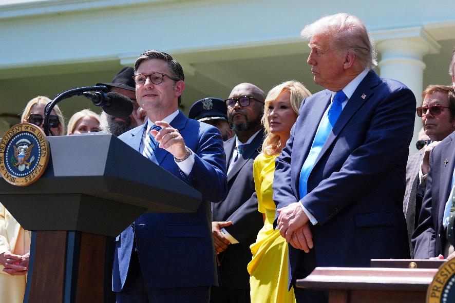 House Speaker Mike Johnson, R-La., speaks as President Donald Trump, right, listens during a National Day of Prayer event in the Rose Garden of the White House, Thursday, May 1, 2025, in Washington. (AP Photo/Evan Vucci)