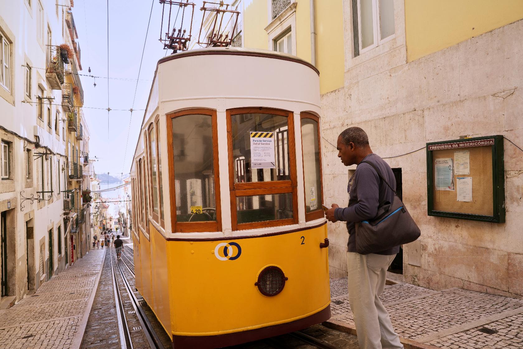 A man reads a sign announcing that the streetcar is out of service in Lisbon, Portugal, Thursday, Sept. 4, 2025. (AP Photo/Ana Brigida)
