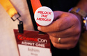 A CinemaCon attendee sports a pin expressing opposition to the proposed Paramount-Warner Bros. Discovery merger during CinemaCon 2026, Tuesday, April 14, 2026, at Caesars Palace, in Las Vegas. (AP Photo/Chris Pizzello)