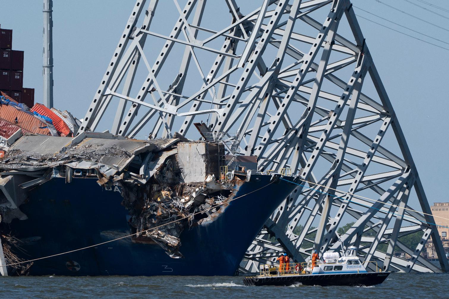 FILE - A boat moves past the bow of the container ship Dali prior to the detonation of explosive charges to bring down sections of the collapsed Francis Scott Key Bridge resting on the Dali, May 13, 2024, in Baltimore. (AP Photo/Mark Schiefelbein,File)