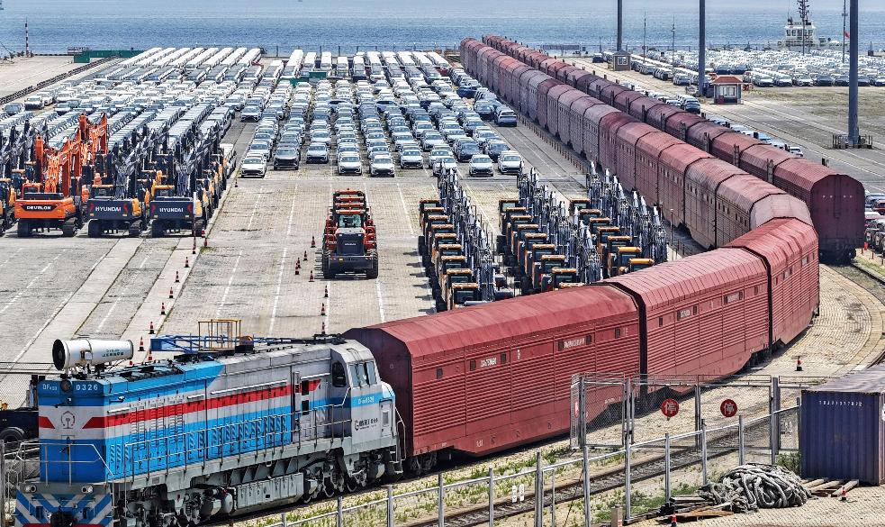 Heavy equipment and cars are prepared for shipment by rail in Yantai, eastern China's Shandong province, on June 20, 2026. (Chinatopix via AP) CHINA OUT