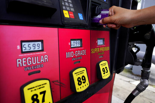 A customer holds a credit card at the pay-at-the-pump gasoline pump in Rolling Meadow, Ill., Thursday, June 30, 2022. U.S consumers have so far defied higher prices for gas, food, and rent and have been spending more in 2022, providing crucial support to the economy. The Wall Street Journal reports that Visa and Mastercard have raised the amount a gas station can hold up to $175 on credit or debit card at the pump. (AP Photo/Nam Y. Huh)