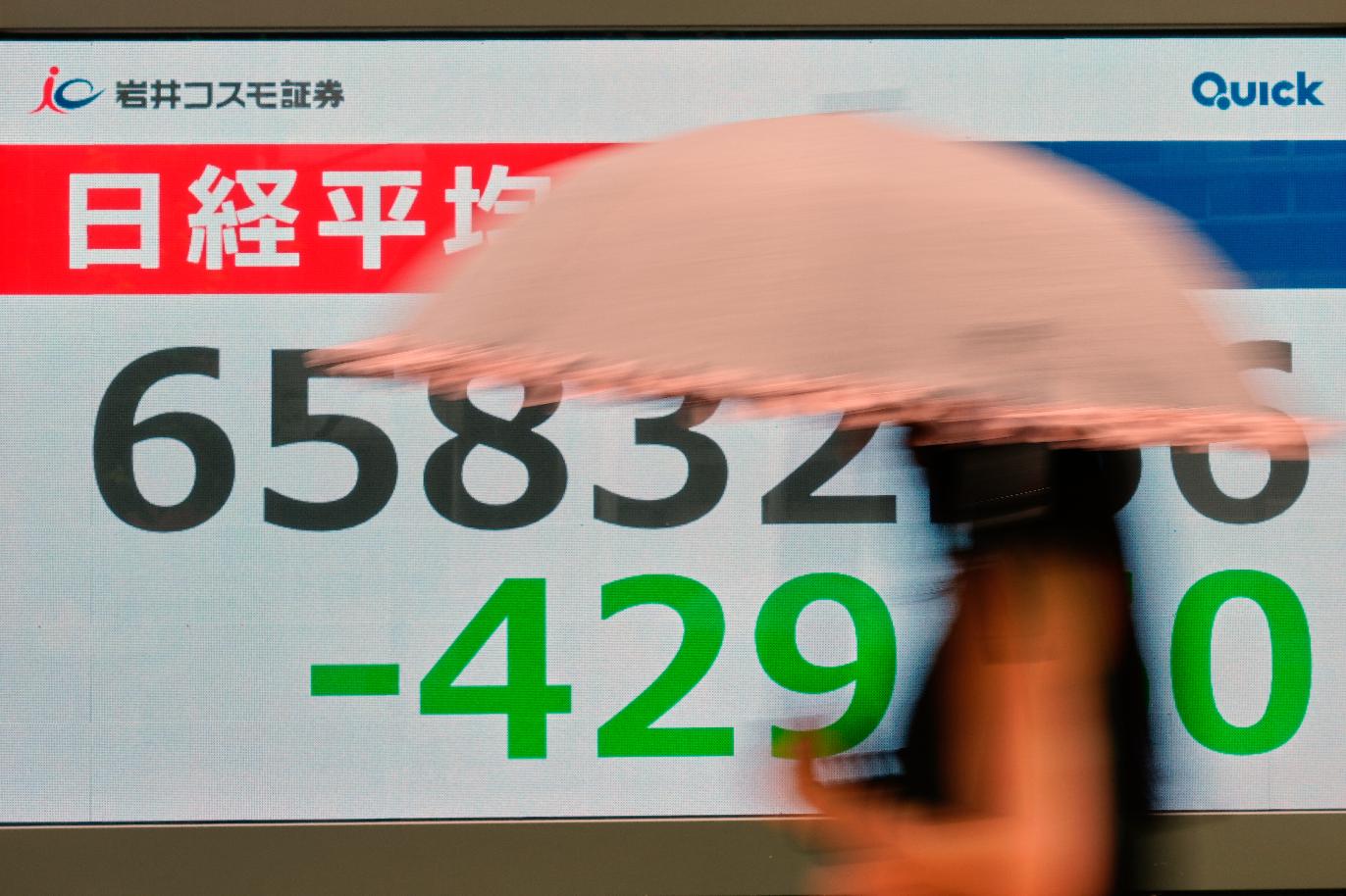 A person walks near an electronic stock board showing Japan's Nikkei index at a securities firm Thursday, Aug. 27, 2026, in Tokyo. (AP Photo/Eugene Hoshiko)