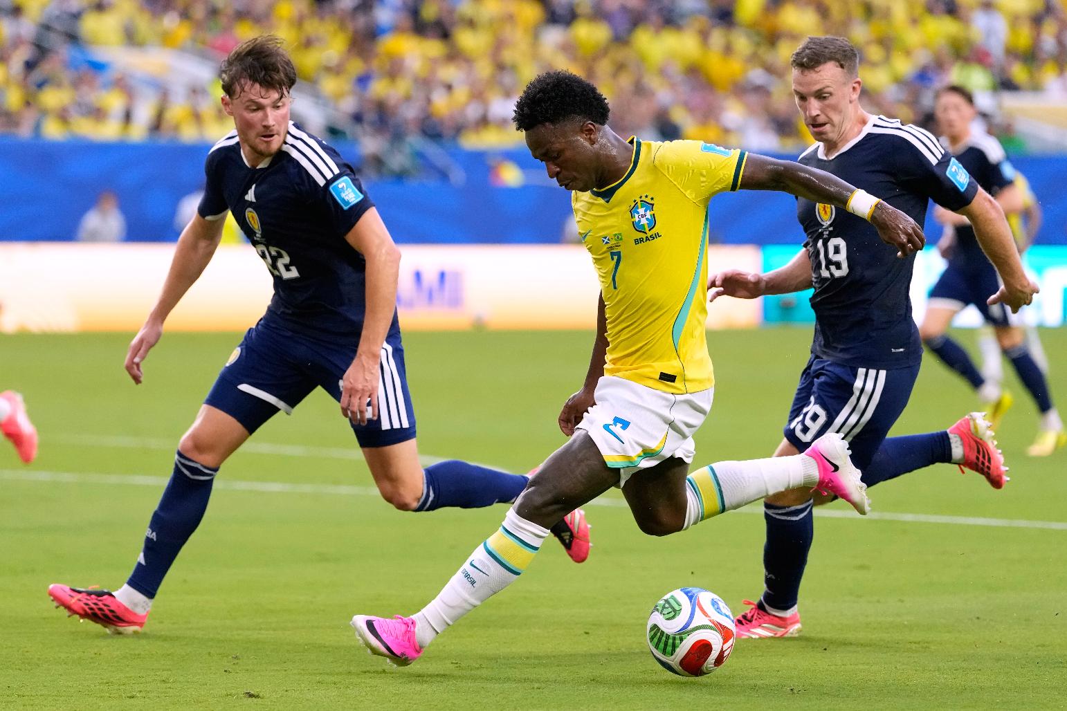 Brazil's Vinicius Junior (7) battles for the ball with with Scotland's Nathan Patterson (22) and Lewis Ferguson (19) during the World Cup Group C soccer match between Scotland and Brazil in Miami Gardens, Fla., Wednesday, June 24, 2026. (AP Photo/Rebecca Blackwell)