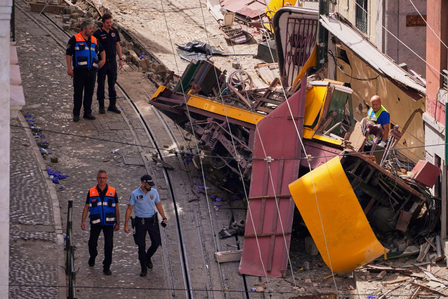 Police officers inspect the site where a tourist streetcar derailed and crashed in Lisbon, Portugal, Thursday, Sept. 4, 2025. (AP Photo/Armando Franca)