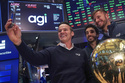 AGI Inc Founder, Executive Chairman & CEO Marciano Testa, left, Governance Officer Lucas Aguiar, center, and Chief Client Officer Matheus Girardi take a selfie photo on the floor of the New York Stock Exchange after their company's IPO began trading, Wednesday, Feb. 11, 2026. (AP Photo/Richard Drew)