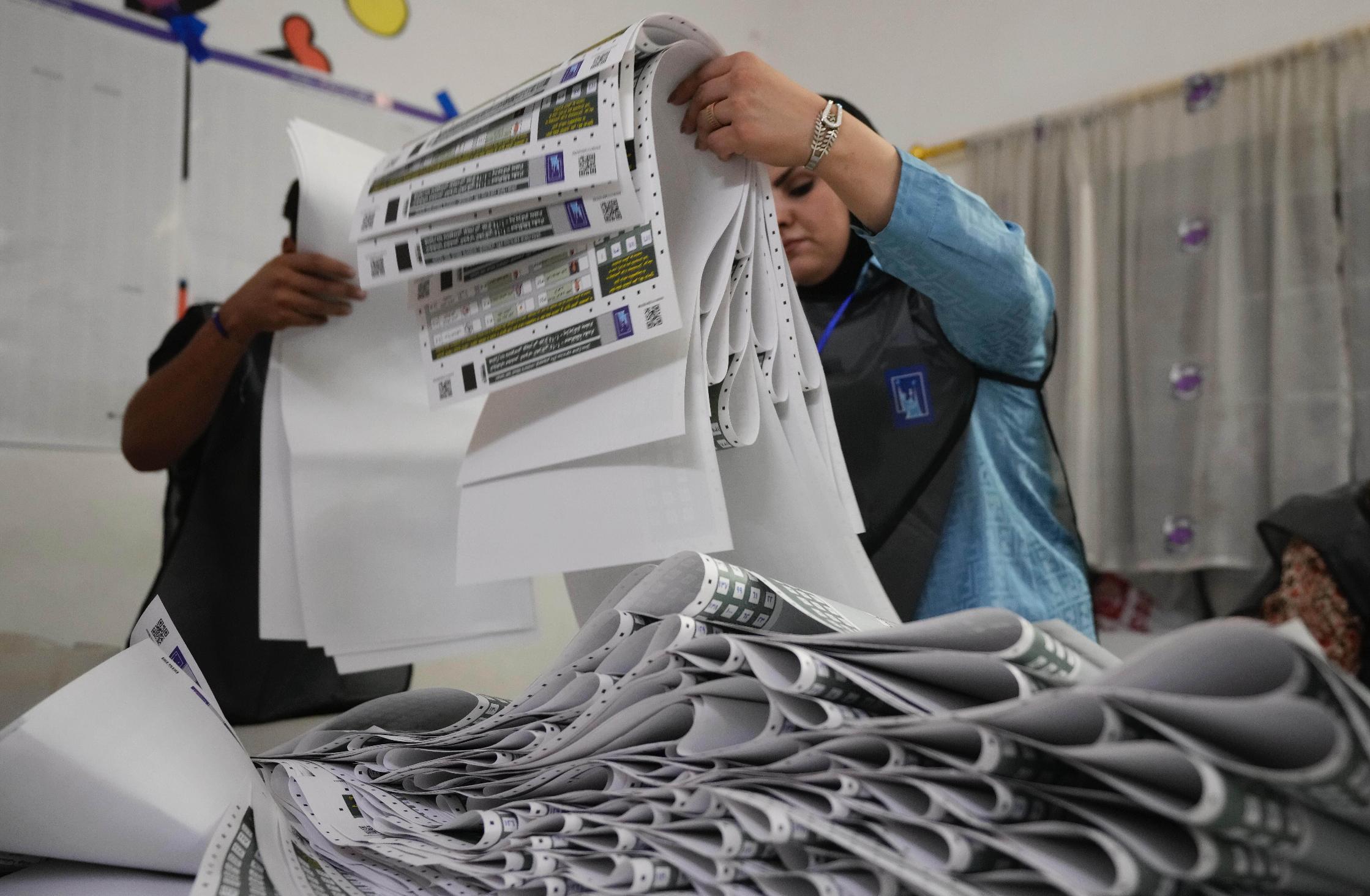 FILE - Election workers gather parliamentary election ballots after the polls closed in Baghdad, Iraq, Nov. 11, 2025. (AP Photo/Hadi Mizban, File)