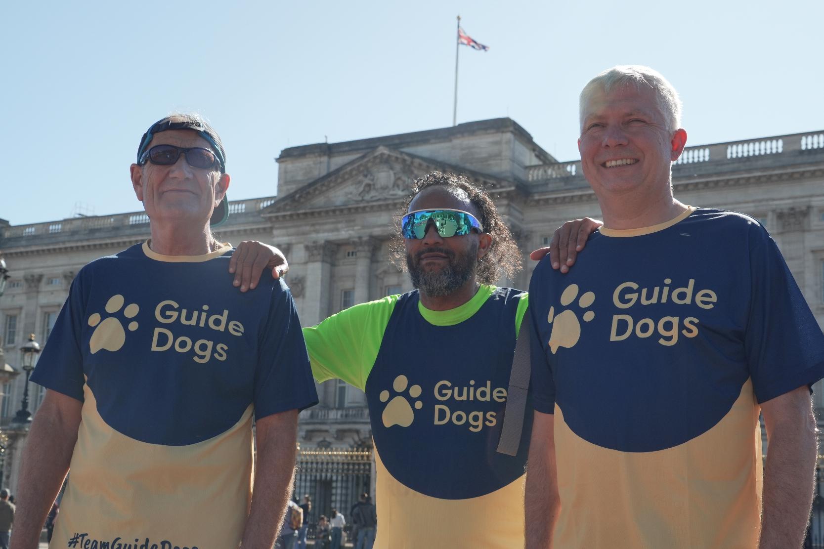 Sha Khan, center, poses in front of Buckingham Palace with his guide runners ahead of London Marathon 2026 in London, Thursday, April 23, 2026. (AP Photo/Mustakim Hasnath)