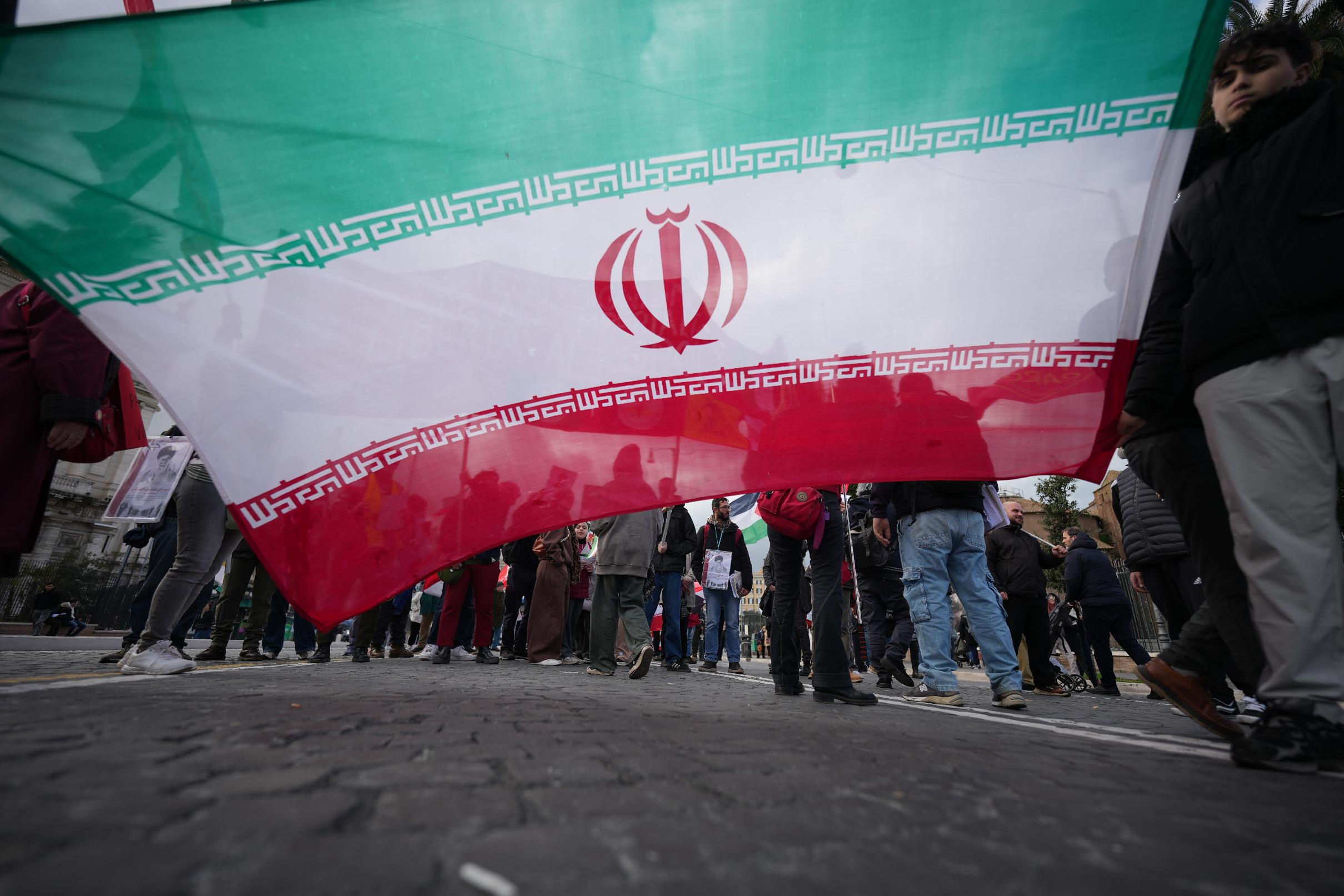 Protesters hold an Iranian flag as they take part in a national demonstration against the war in Iran and the March 22 referendum on the Italian justice system, in Rome, Saturday, March 14 2026. (AP Photo/Andrew Medichini)