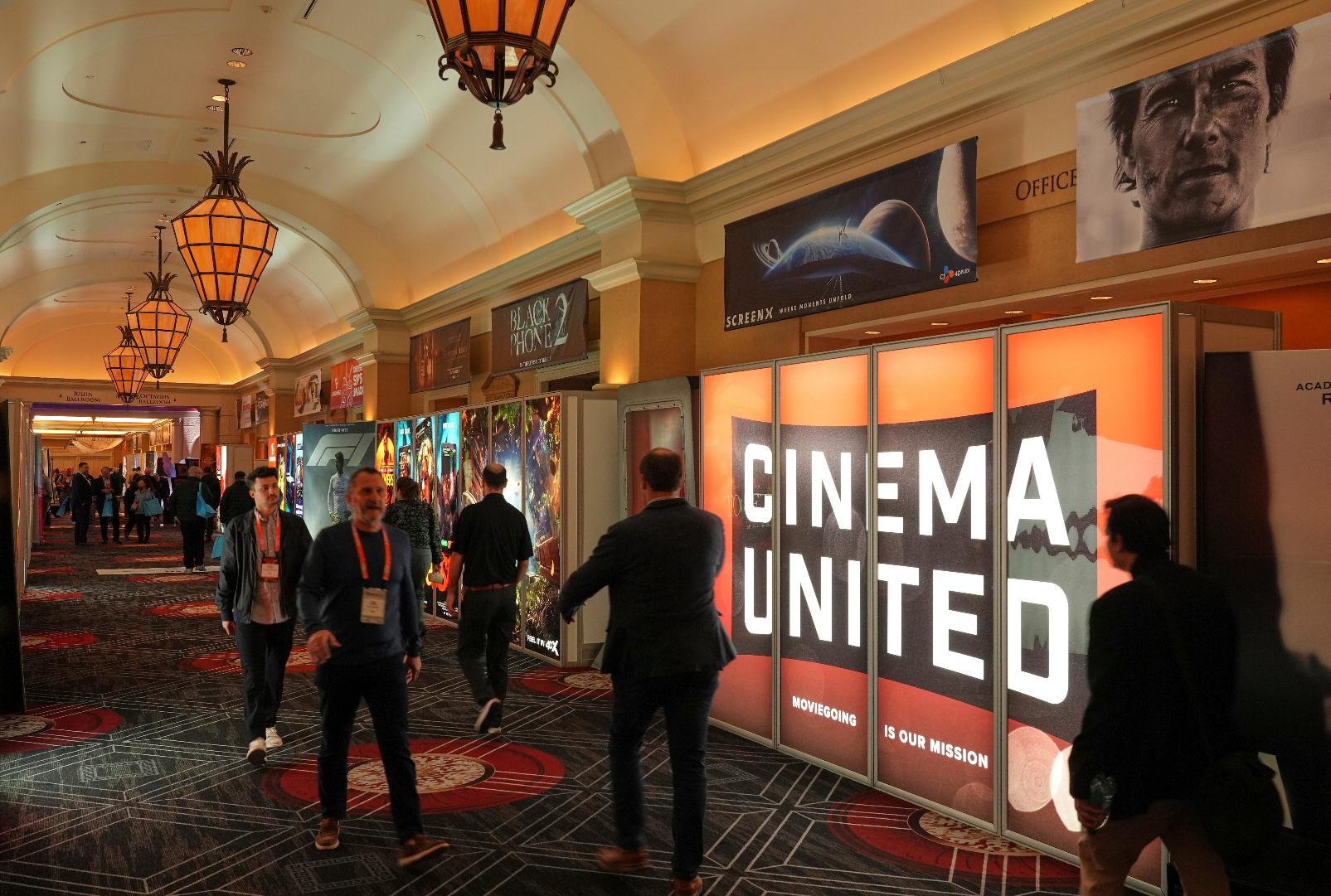 FILE - Attendees walk past a Cinema United advertisement at CinemaCon in Las Vegas on April 2, 2025. (AP Photo/Chris Pizzello, File)